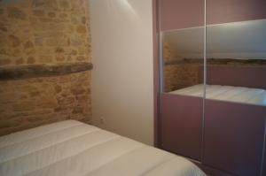 ein kleines Schlafzimmer mit einem Bett und einem Glasschrank in der Unterkunft Les Remparts de Sarlat in Sarlat-la-Canéda