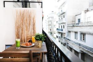 einen Tisch auf einem Balkon mit einem Teller Essen in der Unterkunft Reindeer Apartment in Thessaloniki