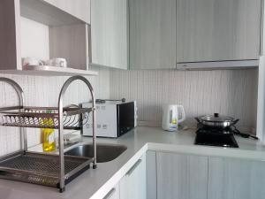 a kitchen with a sink and a microwave at The Prio Signature Condo Chiangmai in Chiang Mai