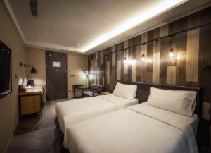 a hotel room with two beds and a television at City Suites - Beimen in Taipei