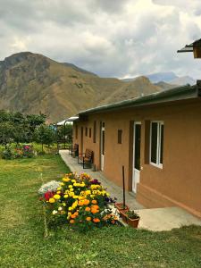 a house with a bunch of flowers in the yard at Piligrim Kazbegi in Kazbegi