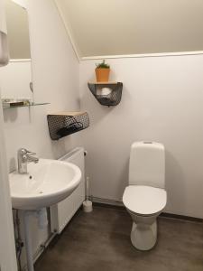 a bathroom with a white toilet and a sink at Hook&Cup in Sorsele