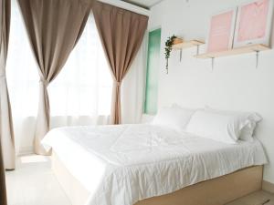 um quarto com uma cama branca e uma janela em Vaincation at Ritze Perdana 2 Damansara Perdana em Petaling Jaya