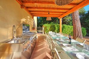 an outdoor kitchen with tables and chairs and aestead at Villa Orchidea by PosarelliVillas in Certaldo