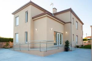 a house with a balcony in front of it at APARTAMENTOS COSTA XUÑO in Porto do Son