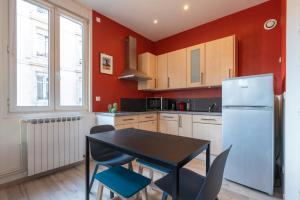 a kitchen with a table and chairs and a refrigerator at Studio Craffe Nancy - Calme Cosy Lumineux et Parking in Nancy