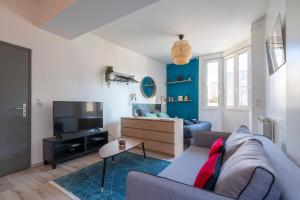 a living room with a couch and a tv at Studio Craffe Nancy - Calme Cosy Lumineux et Parking in Nancy