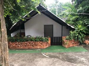 a house with a brick wall and a door at Pine Bungalow Krabi in Klong Muang Beach