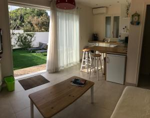 a living room with a table and a kitchen at Les Jasmins in Sainte-Maxime