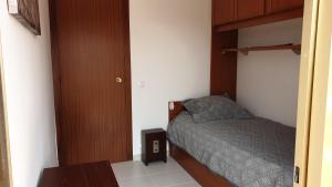 ein kleines Schlafzimmer mit einem Bett und einer Holztür in der Unterkunft Casa Sant Antoni Maria Claret in Cambrils + 21 Fotos
