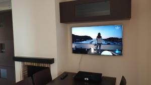 Ein Fernseher hängt an einer Wand mit einer Frau drauf. in der Unterkunft Casa Sant Antoni Maria Claret in Cambrils