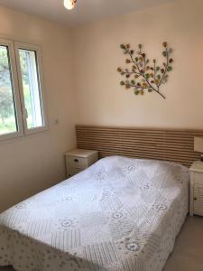 um quarto com uma cama branca e uma árvore na parede em Les Jasmins em Sainte-Maxime