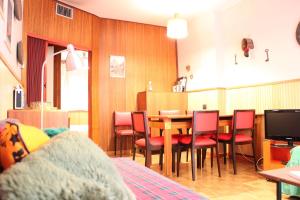 una sala da pranzo con tavolo e sedie rosse di L'Atelier du Temps - DOWNTOWN Apartment a Courmayeur