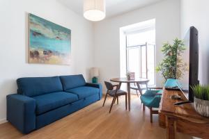- un salon avec un canapé bleu et une table dans l'établissement FLH Restauradores Modern Studios, à Lisbonne