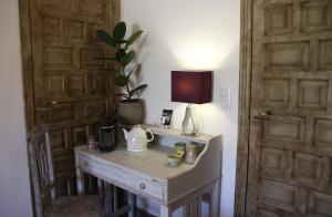 a room with a table with a lamp and a telephone at Villa Foia Vella - adults only in Benichembla