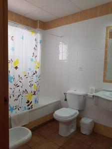 
a bathroom with a toilet, sink, and bathtub at Hotel Oasis Atalaya in Conil de la Frontera

