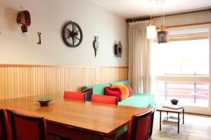 une salle à manger avec une table et un canapé vert dans l'établissement L'Atelier du Temps - DOWNTOWN Apartment, à Courmayeur