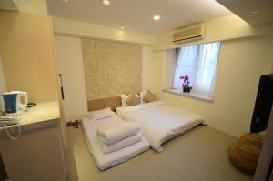 a bedroom with a bed with white sheets and a window at 谷關明高溫泉 Mingao Hot Spring Resort in Heping