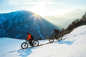 two people riding bikes down a snow covered mountain at Hotel Club Uappala Sestriere in Sestriere