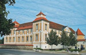 um grande edifício amarelo com um telhado vermelho em Hotel Leonardo em Slovenska Bistrica