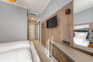 een slaapkamer met een bed en een tv aan de muur bij Smart Stay Hotel Station in München