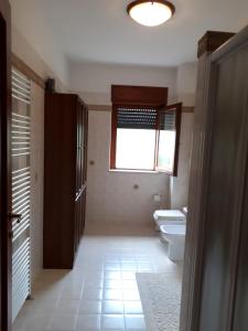 La salle de bains est pourvue de toilettes et d'une fenêtre. dans l'établissement B&B Porta del Gargano, à San Marco in Lamis