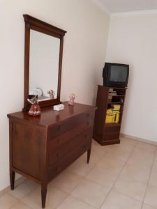 a room with a dresser with a mirror and a tv at B&B Porta del Gargano in San Marco in Lamis +28 photos