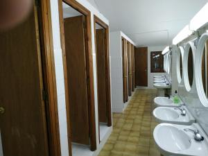 a bathroom with four sinks and a row of toilets at Borda Cortals de Sispony in La Massana