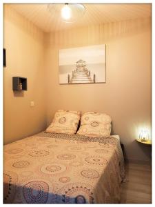 a bedroom with a bed with a picture on the wall at -CAPCIR- Standing, cosy, 50m de la plage, parking, wifi in Canet-en-Roussillon
