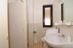 a bathroom with a sink and a toilet and a mirror at Hotel La Rampa in Agnone