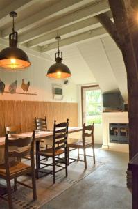 een eetkamer met een houten tafel en stoelen bij B&B “de Boerlarij” in Ruinerwold