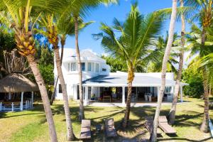 uma casa branca com palmeiras em frente em Villa Eva em Belle Mare