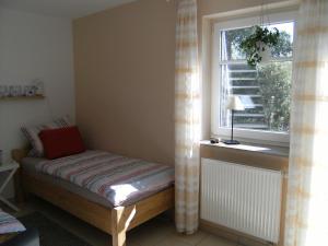 - un petit lit dans une chambre avec fenêtre dans l'établissement Ferienwohnung Schwanbergblick, à Mainbernheim
