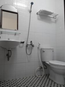 a bathroom with a toilet and a sink and a mirror at Kara Beachside Guesthouse in Da Nang