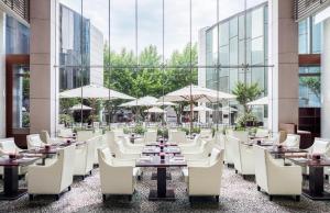 a dining area with tables and chairs and umbrellas at The Langham, Shanghai, Xintiandi in Shanghai