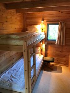 Mandalselva Laksehytter في Marnardal: غرفة نوم مع سريرين بطابقين في كابينة خشب