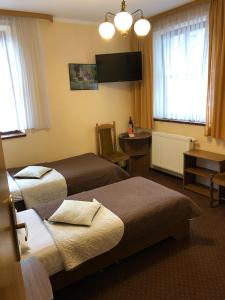 シュチェチンにあるホテル レスタウラツィア ポザムチェのベッド2台とテレビが備わるホテルルームです。
