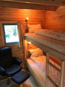 a bedroom with two bunk beds and a chair at Mandalselva Laksehytter in Marnardal