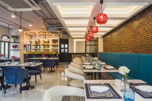 Daraya Boutique Hotel في بانكوك: مطعم بطاولات وكراسي وجدار من الطوب