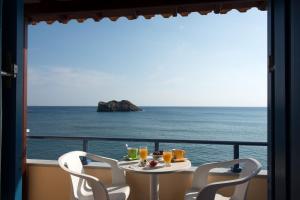 a table with two chairs and a view of the ocean at Hotel Kyma in Skala Eresou