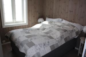 a bedroom with a bed with a quilt on it at Torshaug 4 bedroom cabin in Gol