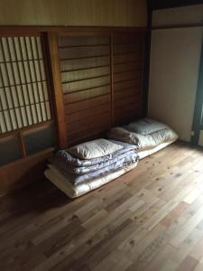 two beds sitting in a room with wooden floors at Kumano Winery Guest House in Tanabe