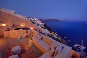 a balcony with a view of the ocean at night at THE A COLLECTION by K&K in Oia