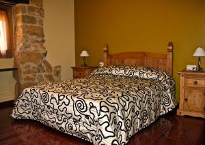 a bedroom with a bed with a black and white comforter at La Serra Rural in Horta de San Joan
