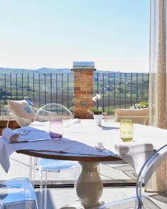 a table with two wine glasses on a balcony at Villa Fontana Relais Suite & Spa in Agliano Terme