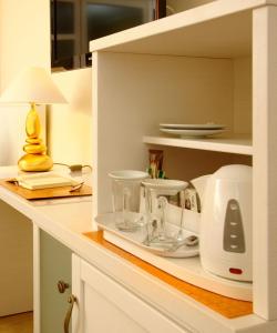 un comptoir de cuisine avec des appareils blancs sur une étagère dans l'établissement Hotel Garni Inselparadies Zingst, à Zingst