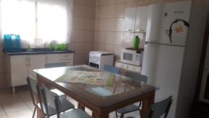 a kitchen with a table and a white refrigerator at Casa beira thermas in Olímpia