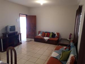 a living room with a couch and a tv at Casa beira thermas in Olímpia