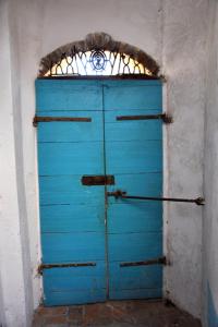 uma porta azul num quarto com uma janela em B&B CasaCorì em Orosei