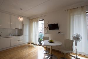 a white kitchen with a table and chairs in a room at Küüni 5B Apartment in Tartu